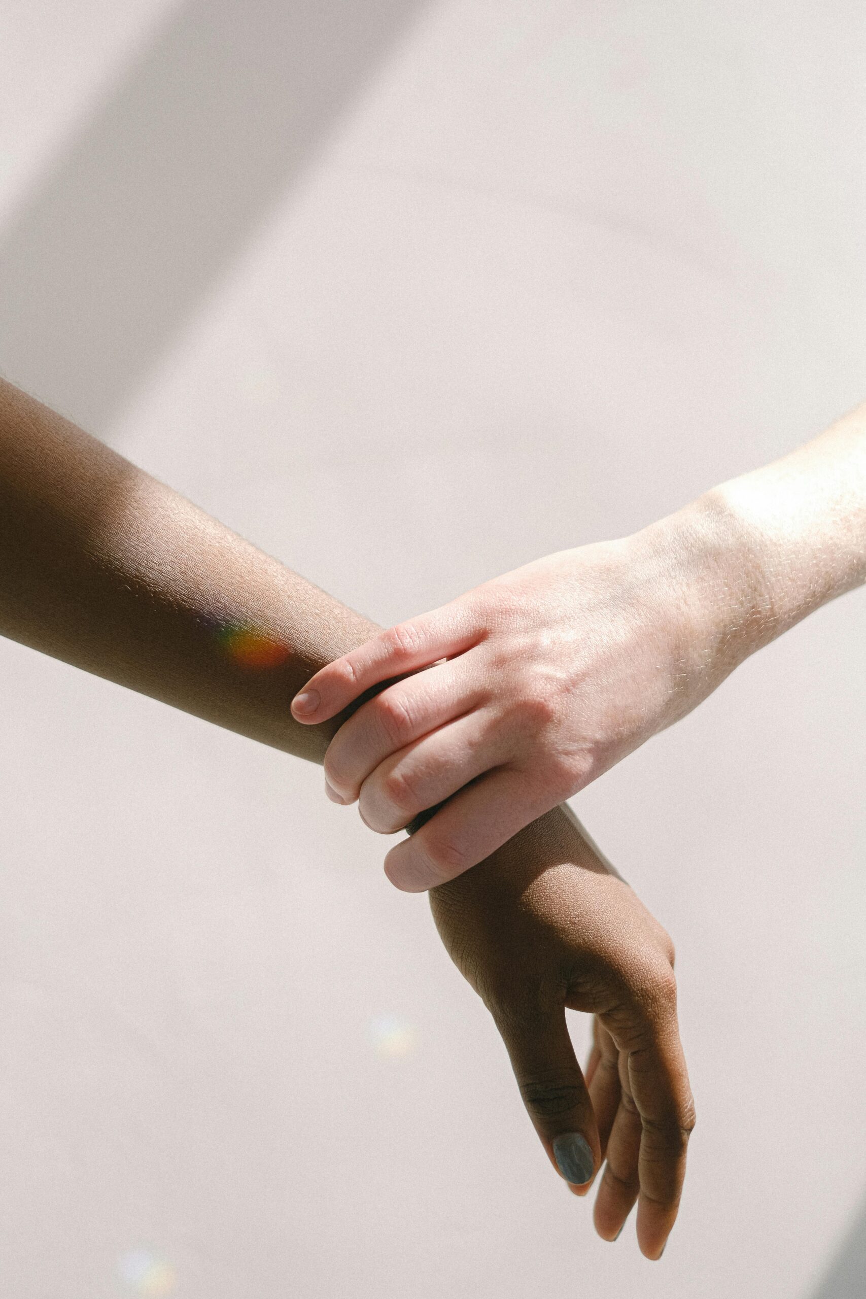 Close-up of diverse hands clasped together, symbolizing unity and support.